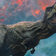 A T.Rex in Jurassic World: Fallen Kingdom roaring triumphantly in front of an erupting volcano.